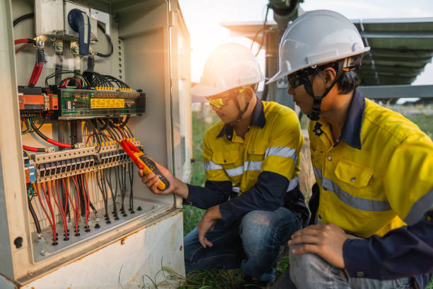 Workers use clamp meter to measure the current of electrical wires produced from solar energy for confirm to normal current.